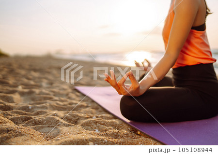 Meditation. Young woman doing yoga near the ocean barefoot. Calmness and balance, healthy lifestyle. Meditation. Young woman doing yoga near the ocean barefoot. Calmness and balance, healthy lifestyle. 105108944