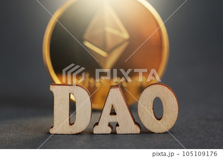 DAO. Decentralized Autonomous Organization. Letter DAO, gold coin cryptocurrency Ethereum on grey background 105109176