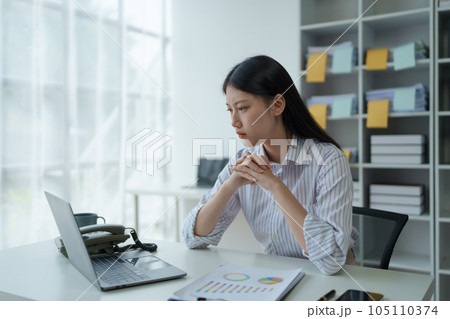 Portrait of business owner, woman using computer and financial statements Anxious expression on expanding the market to increase the ability to invest in business. 105110374