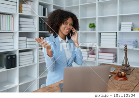 A young women African American lawyer lawsuit studying cases for clients with using smartphone mobile in discussing a law to fight against their parties in the courts. law and attorney concepts 105110504