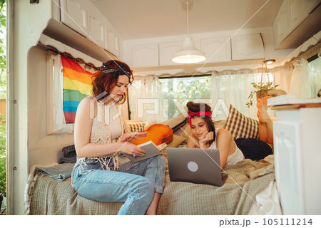 Portrait of a cute lesbian couple. Two girls spend time tenderly together in a camper trailer. Love and attitude. LGBT concept Portrait of a cute lesbian couple. Two girls spend time tenderly together in a camper trailer. Love and attitude. LGBT concept 105111214