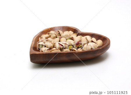 白背景の木製の皿にのせたピスタチオ 105111925