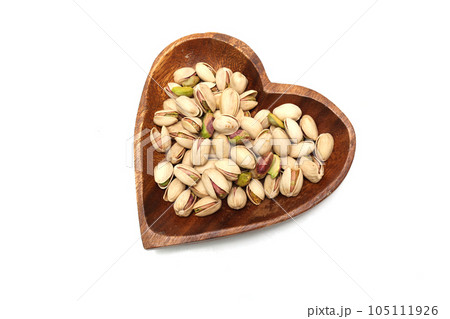 白背景の木製の皿にのせたピスタチオ 白背景の木製の皿にのせたピスタチオ 105111926