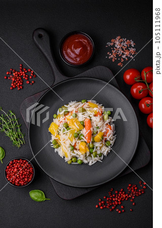Delicious fresh white boiled rice with vegetables carrots, peppers and asparagus beans on a ceramic plate Delicious fresh white boiled rice with vegetables carrots, peppers and asparagus beans on a ceramic plate 105111968