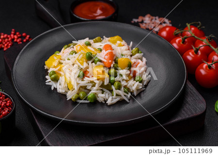 Delicious fresh white boiled rice with vegetables carrots, peppers and asparagus beans on a ceramic plate Delicious fresh white boiled rice with vegetables carrots, peppers and asparagus beans on a ceramic plate 105111969