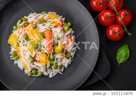 Delicious fresh white boiled rice with vegetables carrots, peppers and asparagus beans on a ceramic plate 105111970