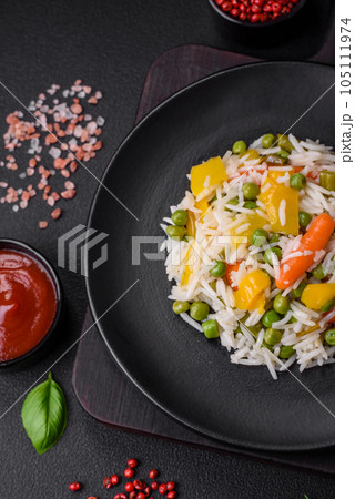 Delicious fresh white boiled rice with vegetables carrots, peppers and asparagus beans on a ceramic plate Delicious fresh white boiled rice with vegetables carrots, peppers and asparagus beans on a ceramic plate 105111974