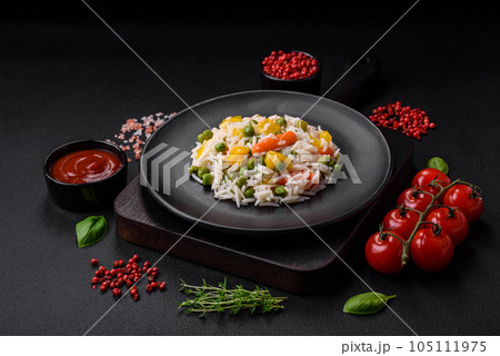 Delicious fresh white boiled rice with vegetables carrots, peppers and asparagus beans on a ceramic plate 105111975