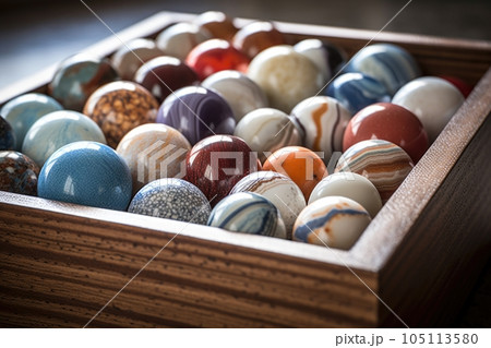 close-up of a marble collection in a wooden box, created with generative ai 105113580