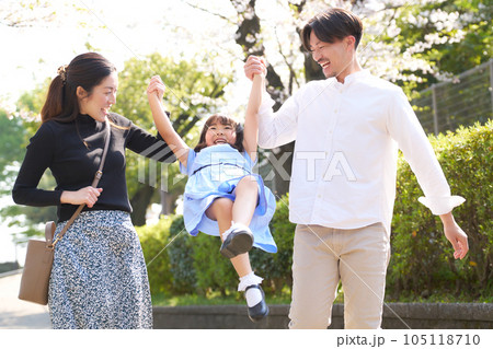 子供の腕を支えて持ち上げる両親 子供の腕を支えて持ち上げる両親 105118710