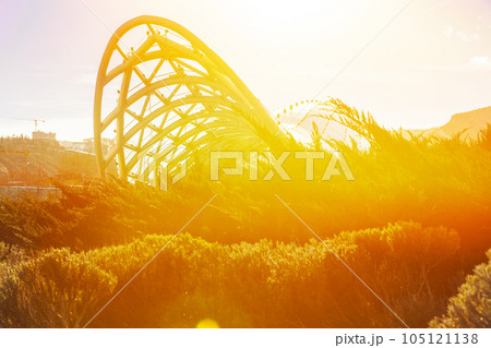 Tbilisi Bridge Of Peace At Twilight. Bridge Of Peace Is A Bow-shaped Pedestrian Bridge Over Kura River In Tbilisi, Capital Of Georgia, Linking Rike Park With Old Town In Central Tbilisi. Important Tbilisi Bridge Of Peace At Twilight. Bridge Of Peace Is A Bow-shaped Pedestrian Bridge Over Kura River In Tbilisi, Capital Of Georgia, Linking Rike Park With Old Town In Central Tbilisi. Important 105121138