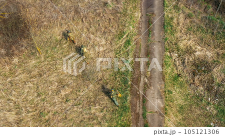 Men Dressed As US American Soldiers Of USA Infantry Of World War II sneaking around In spring Autumn Day. Soldiers prepare mortar for battle In dry grass. Aerial view elevated shot 105121306