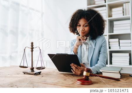 A young women African American lawyer lawsuit studying cases for clients in a law firm to fight against their parties in the courts. law and attorney concepts A young women African American lawyer lawsuit studying cases for clients in a law firm to fight against their parties in the courts. law and attorney concepts 105121471