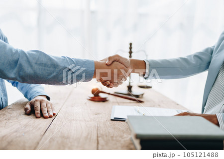 Law, consultation, agreement, contract, lawyer or attorney shakes hands to agree on the client's offer to be hired to fight the parties in court 105121488