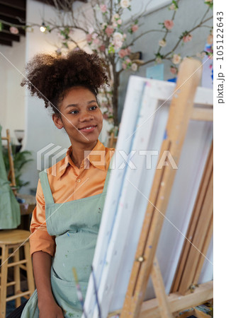 Beautiful american african artist woman painting in art studio at the university classroom 105122643