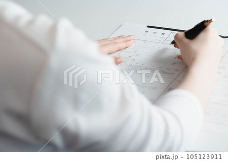 死亡届に記入する女性の手元 105123911