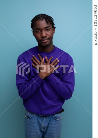 calm african young man with dreadlocks with hands on chest in studio background 105124063