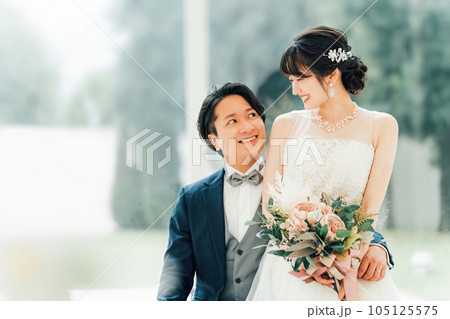 結婚式場で前撮り・フォトウェディングの撮影をする新郎新婦（ブライダル・ウェディング） 105125575