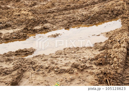 Mud and puddle on a sandy road Mud and puddle on a sandy road 105128623