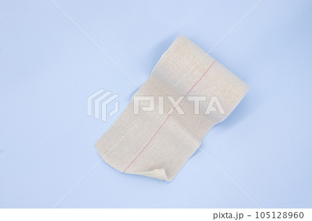 Elastic adhesive bandage on blue background Elastic adhesive bandage on blue background 105128960