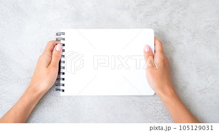 Girl's hands holding notebook Girl's hands holding notebook 105129031