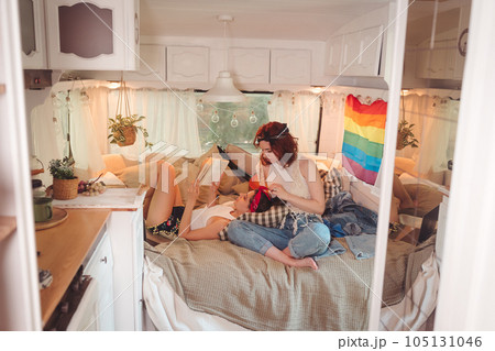 Portrait of a cute lesbian couple. Two girls spend time tenderly together in a camper trailer. Love and attitude. LGBT concept 105131046