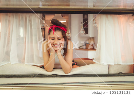 Happy hippie girl is having a good time in a camper trailer. Holiday, vacation, trip concept. Happy hippie girl is having a good time in a camper trailer. Holiday, vacation, trip concept. 105131132