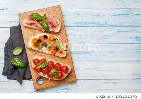 Sandwich set of bruschetta with juicy tomatoes, cheese and prosciutto Sandwich set of bruschetta with juicy tomatoes, cheese and prosciutto 105131545