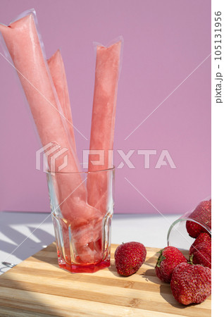 Ice cream in a bag with strawberries, sweet frozen homemade. Brazilian Dindin, chup-chup Ice cream in a bag with strawberries, sweet frozen homemade. Brazilian Dindin, chup-chup 105131956