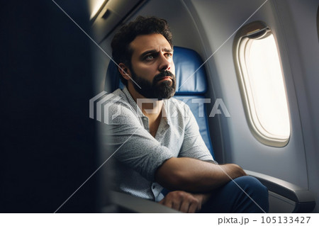 A person sitting on an airplane, looking disappointed. Generative AI 105133427