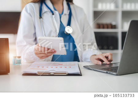 Doctor physician with stethoscope calculate medical fee costs & revenue. practitioner use calculator at Clinic. Doctor physician with stethoscope calculate medical fee costs & revenue. practitioner use calculator at Clinic. 105133733
