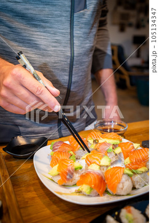 Overhead japanese sushi food. Maki ands rolls with tuna, salmon, shrimp, crab and avocado. Top view of assorted sushi. Overhead japanese sushi food. Maki ands rolls with tuna, salmon, shrimp, crab and avocado. Top view of assorted sushi. 105134347
