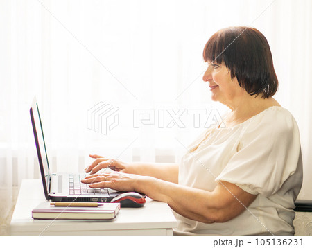 Senior business woman working at her computer at home. Business, education and technology concept. 105136231
