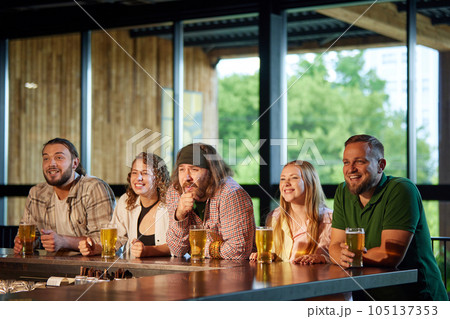 Cheerful people, friends sitting in bar, attentively watching football match translation, drink,ing beer, having fun 105137353