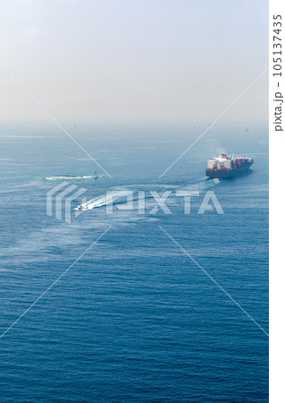 Container ship and a Pilot boat sail the Red Sea 105137435
