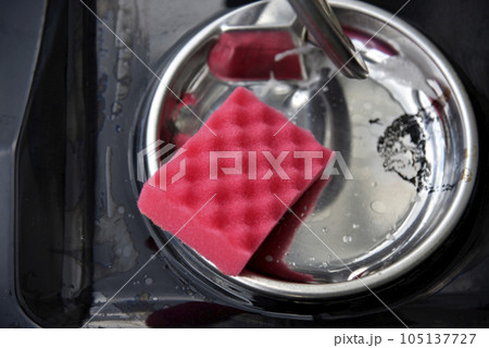 Cleaning the electric stove with a pink brush. Cleaning the kitchen stove. 105137727