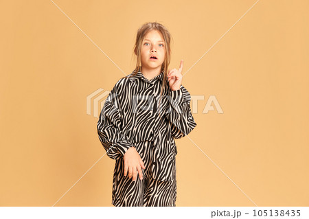 Portrait surprised intellectual girl having good great idea isolated over sandy color background. Concept of idea, answer, analyze, question 105138435