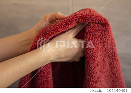 Woman drying her hands with a towel in the bathroom 105140491