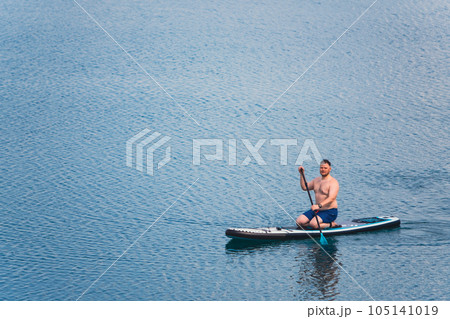 man on paddleboard in the middle of the lake 105141019