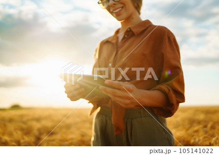Farmer- woman on wheat field with tablet in his hands. Smart farm. Agriculture, gardening concept. 105141022