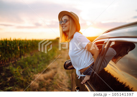Lifestyle! Tourist woman rests and leans out of car window, enjoys trip. Travel concept, vacation. 105141397