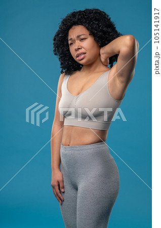 Curly-haired woman suffering from neck pain Curly-haired woman suffering from neck pain 105141917