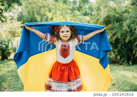 Ukraines Independence Flag Day. Constitution day. Ukrainian child girl in embroidered shirt vyshyvanka with yellow and blue flag of Ukraine in field. flag symbols of Ukraine. Kyiv, Kiev day Ukraines Independence Flag Day. Constitution day. Ukrainian child girl in embroidered shirt vyshyvanka with yellow and blue flag of Ukraine in field. flag symbols of Ukraine. Kyiv, Kiev day 105141918