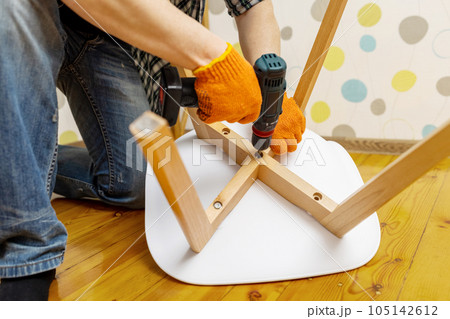 Craftsman collecting with tools, assembling furniture with screwdriver 105142612