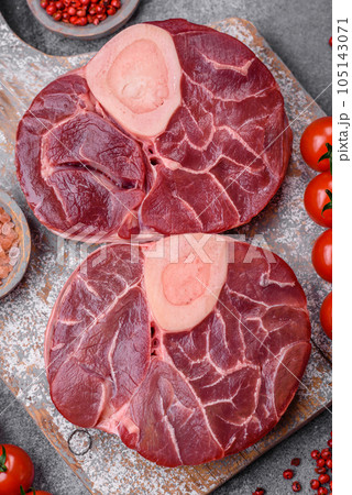 Fresh raw beef steak with bone or ossobuco with salt, spices and herbs Fresh raw beef steak with bone or ossobuco with salt, spices and herbs 105143071