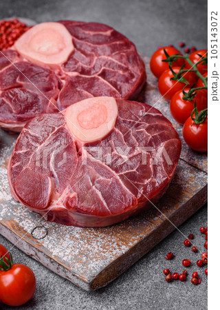Fresh raw beef steak with bone or ossobuco with salt, spices and herbs Fresh raw beef steak with bone or ossobuco with salt, spices and herbs 105143072