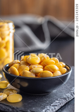 Lupini beans in brine. Pickled lupin in bowl on black table. 105143309