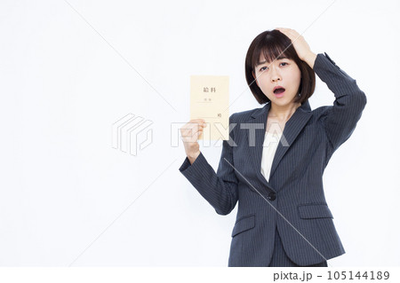 白い背景の前で給料袋を持ち頭を抱える30代のビジネスウーマン 白い背景の前で給料袋を持ち頭を抱える30代のビジネスウーマン 105144189