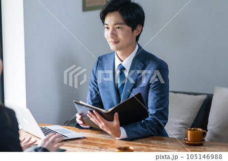 顧客に耳を傾け、熱心に対応する若いビジネスマン 顧客に耳を傾け、熱心に対応する若いビジネスマン 105146988