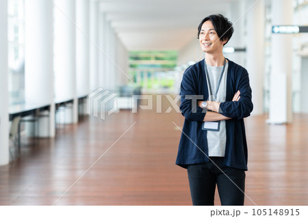 オフィスの廊下で腕組みをする若い男性 105148915